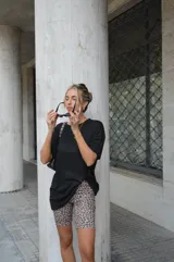 Conjunto de remera negra oversize y biker estampada con manchas color crema y negro.