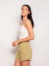 Short color verde militar, tiro alto, corte amplio, con pinzas en el frente, bolsillos laterales y traseros, y dobladillo arremangado.