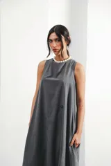 Vestido largo gris sin mangas, con escote redondo, bolsillos laterales y logo bordado en el frente.