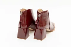 Botinetas plateadas de cuero con punta fina y taco geométrico.