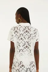 Camisa de encaje negra con botones frontales y mangas cortas.