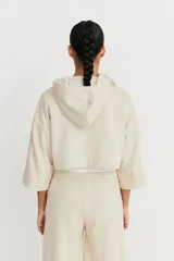 Campera color beige de mangas 3/4 con capucha y cierre frontal.