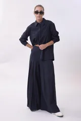 Pantalón palazzo plisado color azul marino, de tiro alto con bolsillos laterales y cierre frontal con botón.