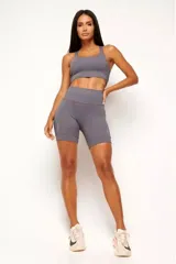 Conjunto deportivo gris compuesto por un top con diseño nadador, bolsillo trasero, bolsillo interno frontal y detalles reflectivos, y un biker con cinturón 360° con bolsillo interno, dos bolsillos laterales y recortes estratégicos.
