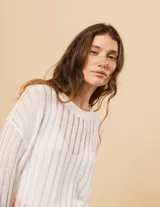 Sweater de algodón blanco con escote redondo y manga larga, con detalle de calado en punto desagujado.