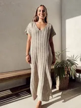 Vestido largo color beige, de tejido calado, escote en V, manga corta y corte holgado.