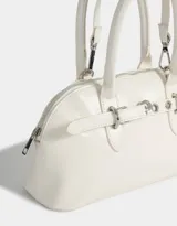 Cartera bowling color blanco crudo de cuerina, con doble asa corta de mano, cierre superior y asa larga regulable y desmontable.