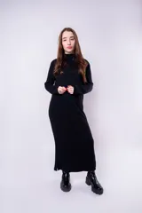 Vestido largo negro de tejido de punto, con cuello alto y mangas largas.