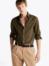 Camisa verde militar de popelín de algodón con tecnología Flex, corte regular, cuello con botones, puños redondeados con botón y logo de Tommy Hilfiger bordado en el pecho.