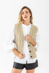 Chaleco negro de punto con diseño trenzado, escote en V y cierre frontal con botones.