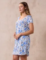 Camisón corto de tejido suave con estampado floral en tonos celeste y azul. Tiene mangas cortas, escote redondo con ribete gris y detalle plisado en el delantero.