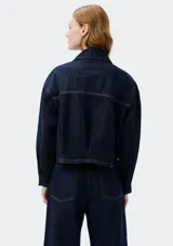 Campera de jean azul, con cierre frontal y cuello clásico, de corte recto y mangas largas.