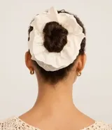 Scrunchie de tela laise color crema con diseño calado.