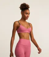 Top deportivo reversible en microfibra doble faz, color rosa con tiras grises. Tiene escote en V, breteles finos paralelos y copas removibles.