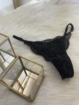 Tanga de encaje negro con corte de media colaless, regulable y con entrepierna de algodón.