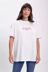 Remera blanca de corte holgado con estampa roja que dice 'sunrise to sunset LOS ÁNGELES CALIFORNIA'.