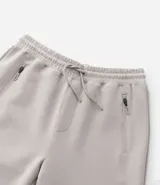 Pantalón deportivo de hombre color beige, liso, con ajuste elástico en la cintura y bolsillos laterales.