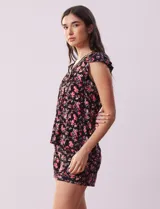 Conjunto de pijama de short y remera de tejido soft estampado, con escote en V con aplique de puntilla, botones y detalle plisado. El short tiene cintura elastizada.