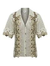 Chaleco tejido a crochet con diseño de flores en tonos beige y crudo, con cuello camisero y cierre frontal con botones de madera.