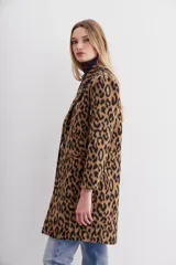 Tapado de paño con estampado animal print, de calce recto y solapas angostas. Tiene botones al frente y bolsillos ojal.