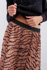 Falda midi plisada con estampado animal print de cebra en tonos beige y marrón. Tiene cintura elástica.