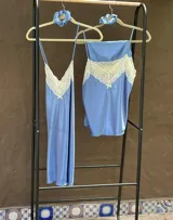 Camisón azul de satén con breteles finos y escote en V con puntilla blanca.