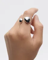 Anillo abierto de plata con dos esferas en los extremos.