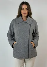 Campera estilo motoquera confeccionada en paño de lana color gris oscuro, con cuello solapa asimétrico y cierre cruzado con cremallera.