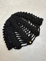 Casquete de crochet color rojo, con diseño de malla y confeccionado en hilo de algodón.