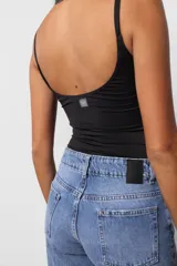 Body negro ajustado al cuerpo, con escote redondo y breteles finos. Tiene broches snap en la entrepierna y logo estampado en la espalda.