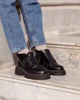 Botinetas negras de cuero con suela track y ajuste con velcro.