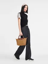 Cartera plegable de nylon con cierre y asa corta, diseño compacto y funcional.