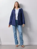 Campera impermeable azul con cierre central, bolsillos delanteros y lazo de ajuste en la cintura. Tiene avíos metálicos plateados y cierre oculto en la espalda para autoguardado.