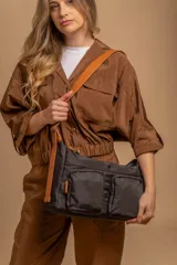 Bandolera de tafeta impermeable, liviana, con dos compartimientos principales, dos bolsillos con cierre y correa regulable con hebilla.