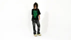 Remera negra de corte regular fit, confeccionada en jersey de algodón grueso. Estampa frontal con diseño de cruz y calaveras en color verde.