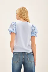 Remera blanca de algodón con mangas balloon de broderie, cuello redondo y tajos laterales.