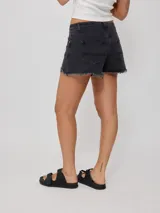 Short de jean negro con roturas y terminaciones desflecadas.