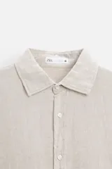 Camisa celeste de lino, de corte recto, manga larga y cuello clásico.