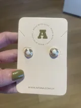 Par de aros Aitana de metal plateado con diseño circular y centro de perla blanca.