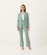Pantalón recto con estampado de cuadros verdes y blancos, cierre con botón y cremallera, y bolsillos delanteros.