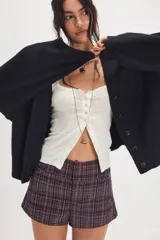 Cárdigan negro de silueta oversized, confeccionado en hilo de algodón suave con terminaciones acanaladas, escote en V, hombros caídos y mangas largas amplias.