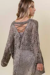 Buzo tejido liviano color bronce/marrón con diseño calado y textura sutilmente brillante. Presenta un calce amplio y mangas amplias, con detalle de tiras entrecruzadas en la espalda.