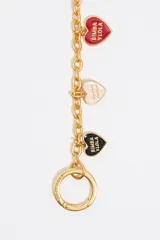 Charm para bolso de cadena de metal dorado con mosquetones en los extremos y dijes colgantes en forma de corazón con el logo de Bimba y Lola en varios colores: negro, rojo y blanco.