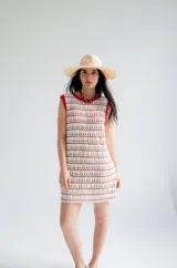 Vestido corto tejido a crochet color marrón con rayas horizontales blancas y cuello y sisas con borde rojo.