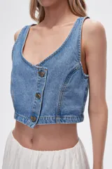 Chaleco crop top de jean celeste con botones frontales.