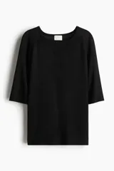 Remera negra de corte holgado en punto transparente, con cuello redondo y mangas raglán al codo.