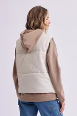 Chaleco puffer negro con cierre frontal con botones a presión y cuello alto.