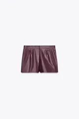Shorts de tiro alto color borgoña, con bolsillos delanteros y cierre frontal con cremallera y ganchos metálicos.