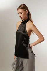 Top negro sin mangas, con cuello halter y espalda descubierta.