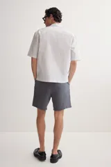 Short gris oscuro de lino y algodón, corte relaxed fit, con cintura elastizada ajustable con cordón, bolsillos laterales y bolsillo trasero.